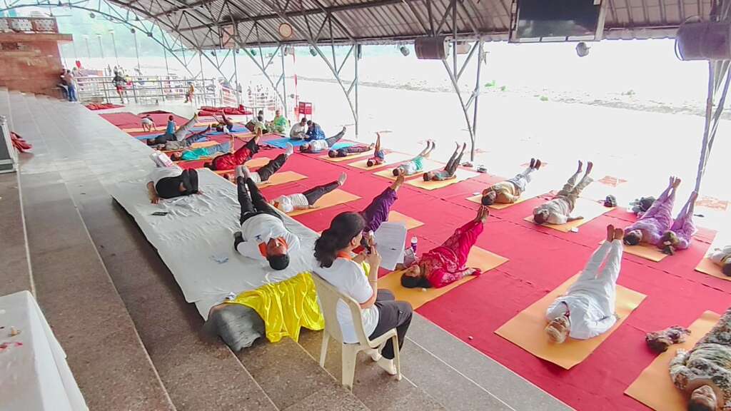 ऋषिकेश: आयुर्वेद विभाग ने गंगा आरती के साथ त्रिवेणी घाट पर आयोजित किया योग शिविर, किया योगाभ्यास