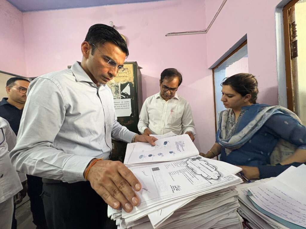 विकासनगर उप निबंधक कार्यालय का निरीक्षण करते जिलाधिकारी, दस्तावेजों की जांच के दौरान गंभीर अनियमितताएं उजागर होती हुईं।