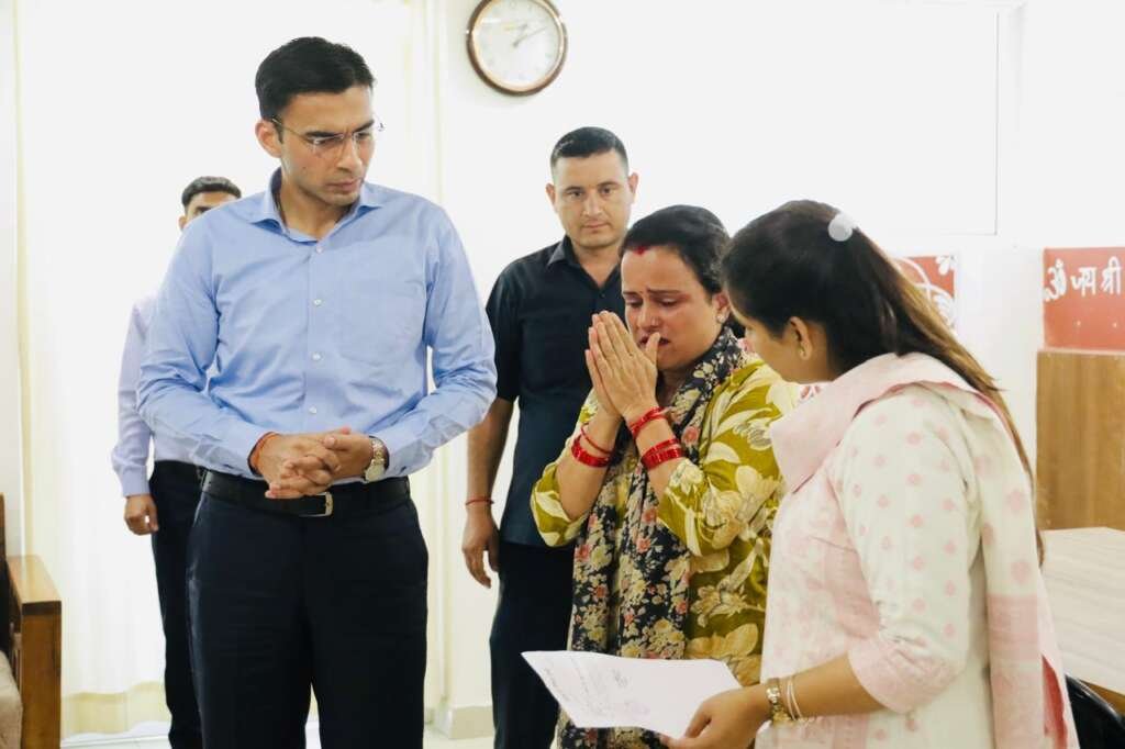 देहरादून में जिलाधिकारी सविन बंसल कैंसर पीड़ित परिवार को आर्थिक सहायता प्रदान करते हुए।