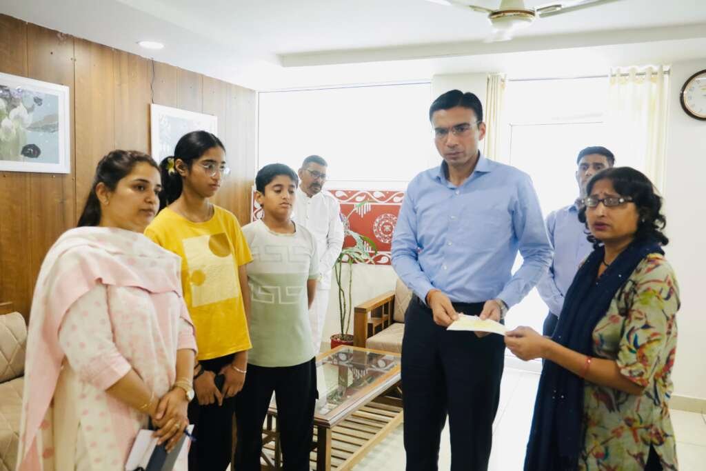 देहरादून में जिला प्रशासन द्वारा कैंसर पीड़ित विधवा महिला सुनीता कलवार को आर्थिक सहायता प्रदान करते अधिकारी।