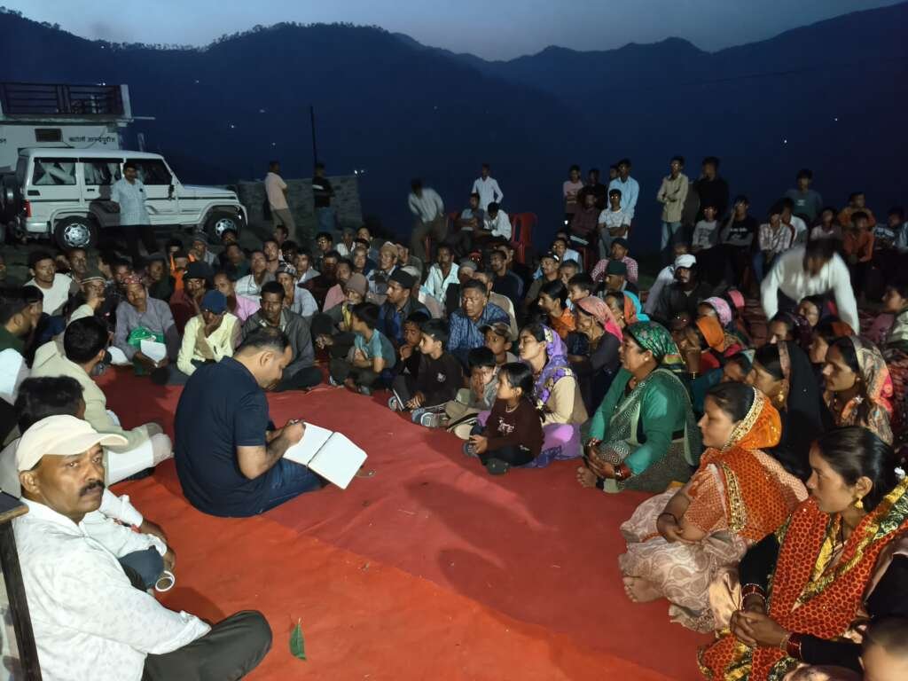 दूरस्थ गांव खटोली में आयोजित रात्रि चौपाल में ग्रामीणों से बातचीत करते चम्पावत के जिलाधिकारी मनीष कुमार।