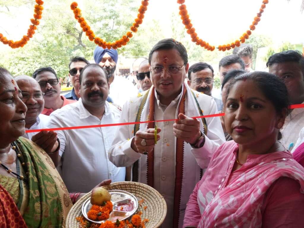 मुख्यमंत्री पुष्कर सिंह धामी विकासखंड परिसर में विकास योजनाओं के लोकार्पण के दौरान मंच पर रिबन काटते हुए।