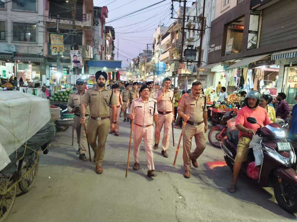 पुलिस बल द्वारा फ्लैग मार्च करते हुए सुरक्षा व्यवस्था का प्रदर्श