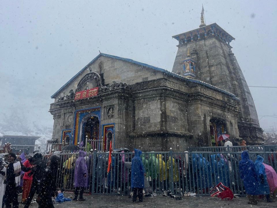 केदारनाथ धाम में हो रही बर्फबारी के दौरान श्रद्धालुओं की सहायता करते पुलिसकर्मी।