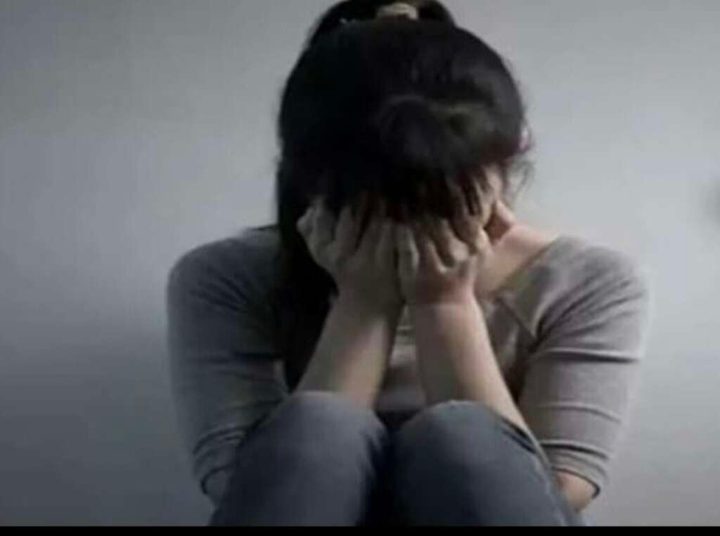 प्रतीकात्मक तस्वीर में परेशान युवती।