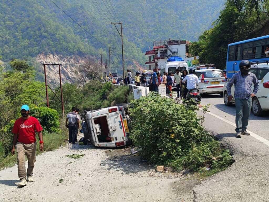 रुद्रप्रयाग हाईवे पर दुर्घटनाग्रस्त मैक्स वाहन के पास राहत कार्य करते पुलिस और बचाव दल
