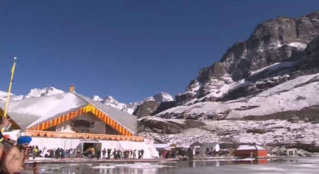 हेमकुंड साहिब में कपाट खुलने के दौरान श्रद्धालु और फूलों से सजा गुरुद्वारा।