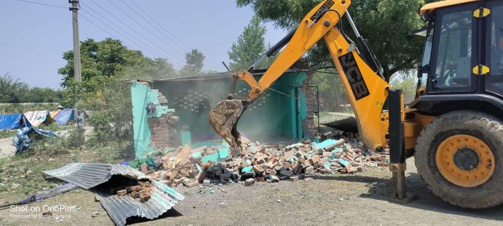 देहरादून के शीशमबाड़ा क्षेत्र में अतिक्रमण हटाने की कार्रवाई के दौरान चल रहा बुलडोजर।