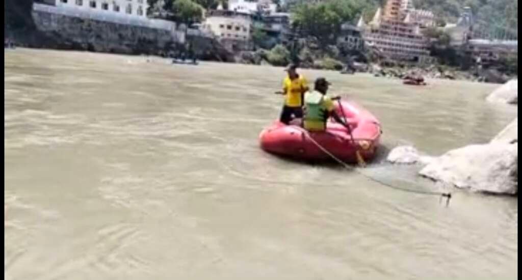 गंगा नदी के घाट पर एसडीआरएफ और पुलिस की टीम बोट व गोताखोरों के साथ सर्च ऑपरेशन करती हुई।