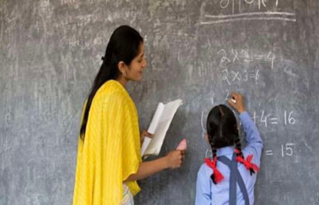 कक्षा में विद्यार्थियों को पढ़ाते हुए शिक्षिका का प्रतीकात्मक चित्र।