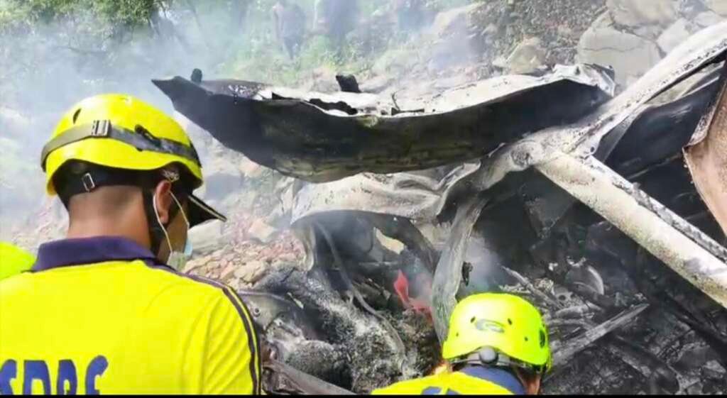 दुर्घटना के बाद खाई में क्षतिग्रस्त और जली हुई कार के पास रेस्क्यू अभियान चलाती SDRF टीम।