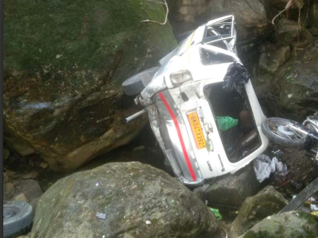 नैनीताल के भुजियाघाट क्षेत्र में भीषण टक्कर के बाद खाई में गिरी कार और बुलेट।