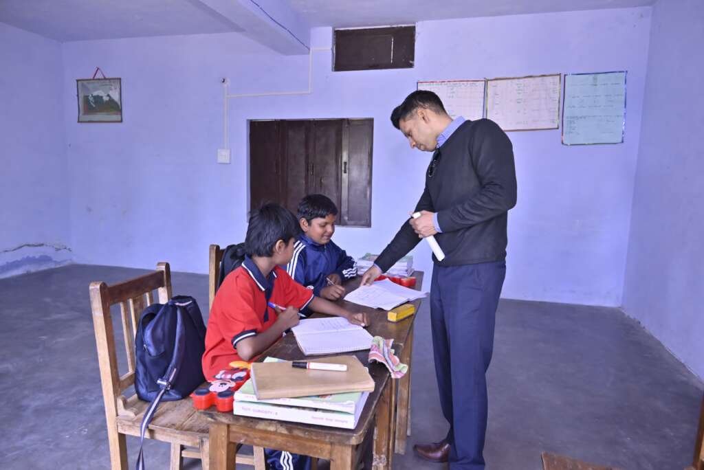 अल्मोड़ा के कसार देवी बालिका पूर्व माध्यमिक विद्यालय मटेना में बच्चों को पढ़ाते जिलाधिकारी अंशुल सिंह